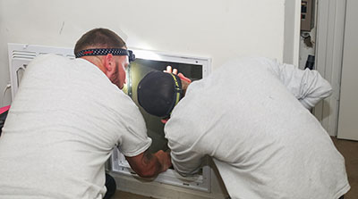 Workers looking at a duct