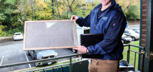 Energy Solutions employee holds dirty air filter
