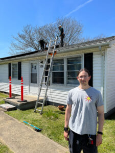 Kris Van Zandt in front of his home