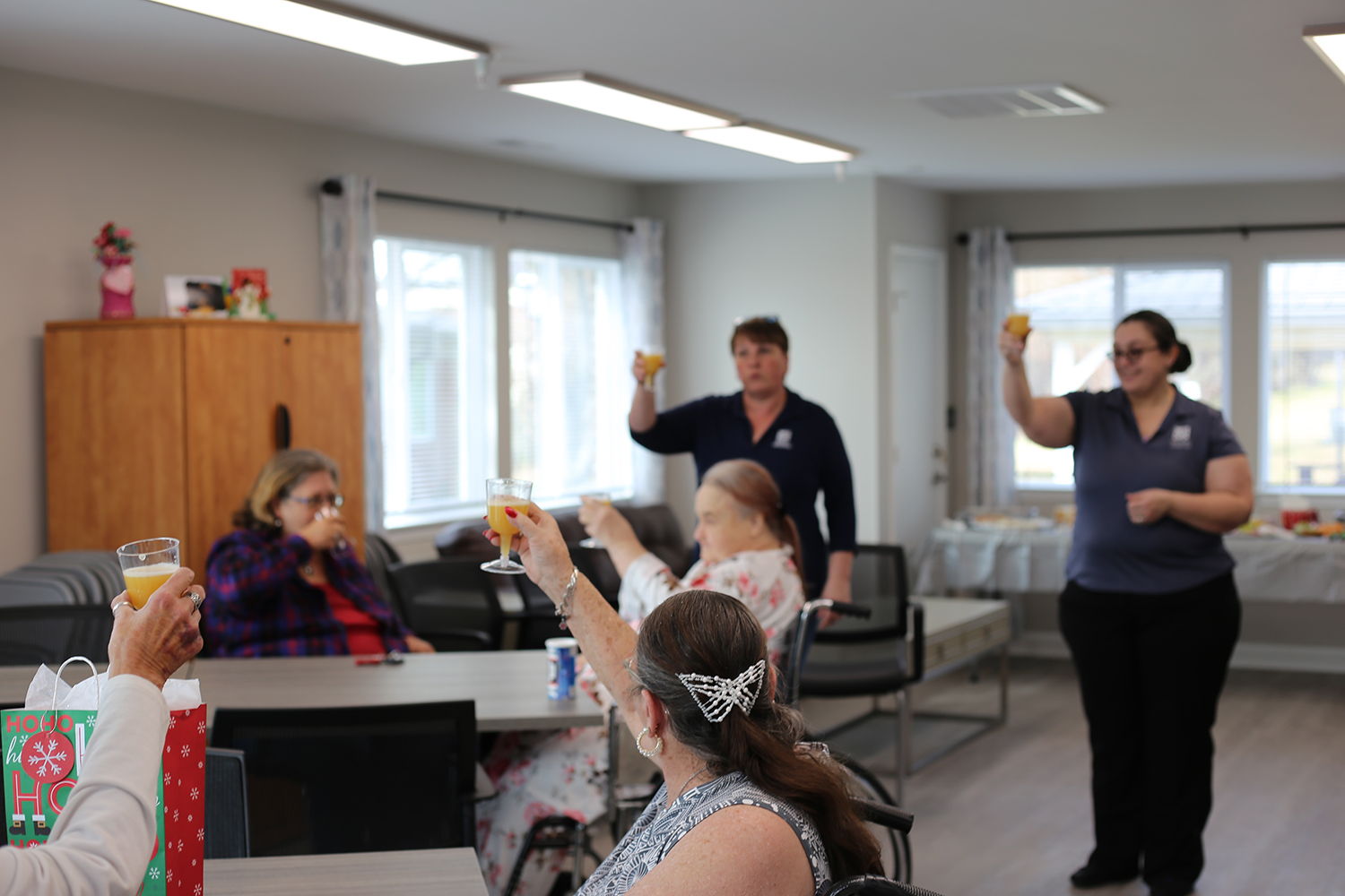 Grayson Manor residents raise a glass of punch to celebrate the recently refurbished community center and the completion of renovations at the property.